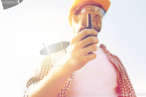 Image of close up of builder in hardhat with walkie talkie