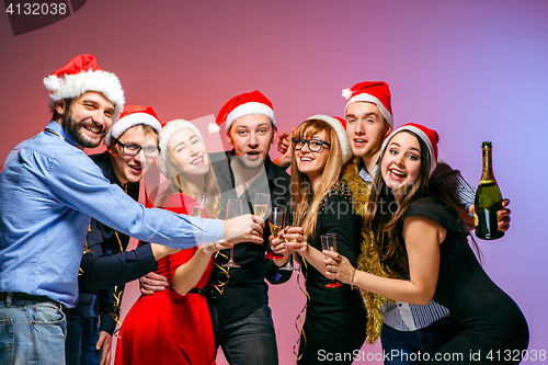 Image of Many young women and men drinking at christmas party