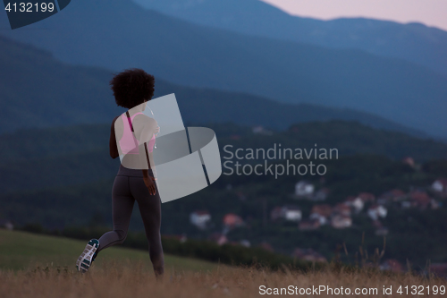 Image of Young African american woman jogging in nature