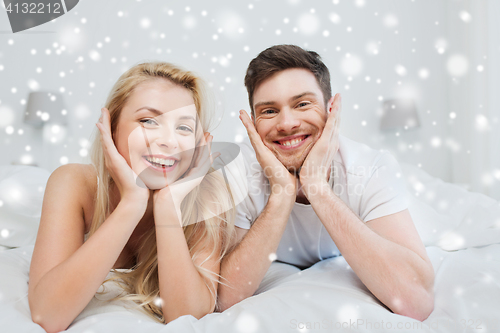 Image of happy couple lying in bed at home