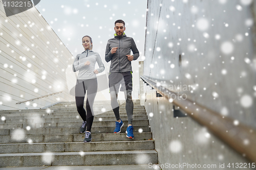 Image of couple of sportsmen running downstairs outdoors