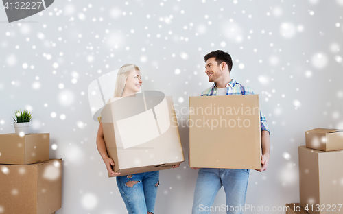 Image of smiling couple with big boxes moving to new home