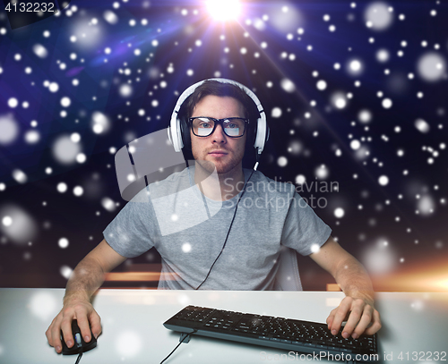 Image of man in headset playing computer video game