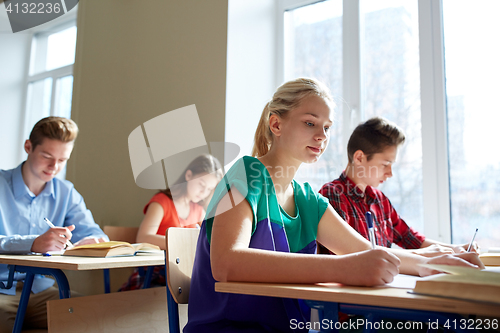 Image of group of students with books writing school test