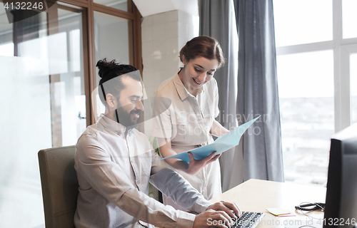 Image of happy creative team with computer in office