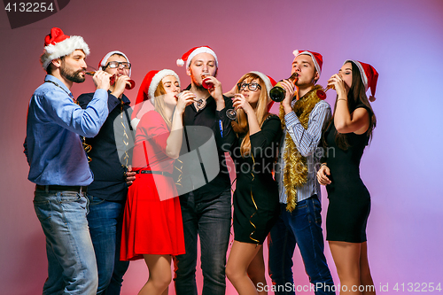 Image of Many young women and men drinking at christmas party