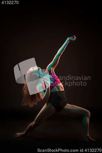 Image of Young beautiful dancer in beige dress dancing on black background