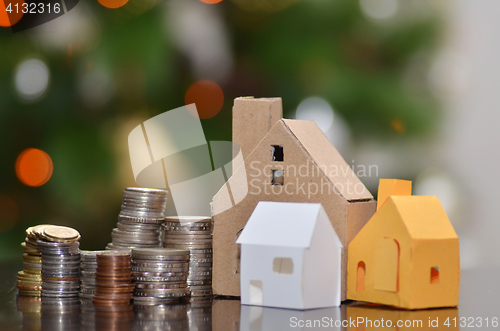 Image of Paper house and stacks of coins standing