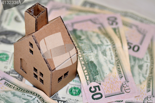 Image of Miniature paper made house stand on  money