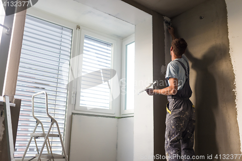 Image of Plasterer renovating indoor walls and ceilings. Construction finishing works.