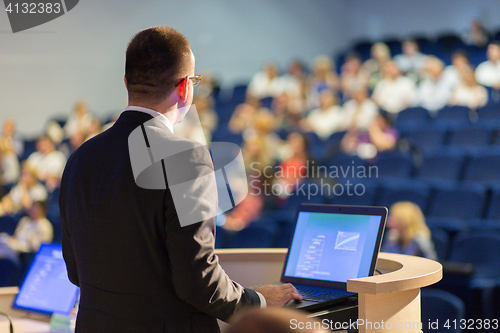 Image of Public speaker giving talk at business event.