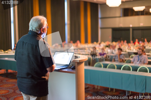 Image of Senior public speaker giving talk at scientific conference.