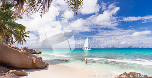 Image of Woman enjoying Anse Patates picture perfect beach on La Digue Island, Seychelles.