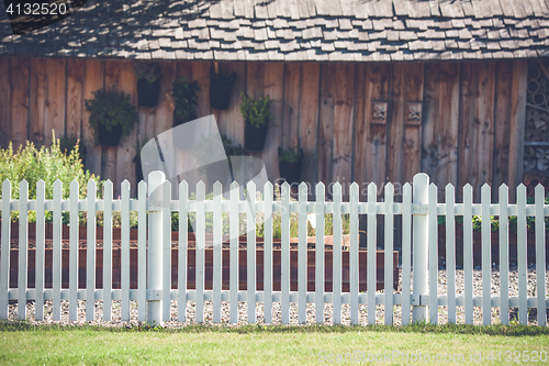 Image of White picket fence in front af a wooden shed