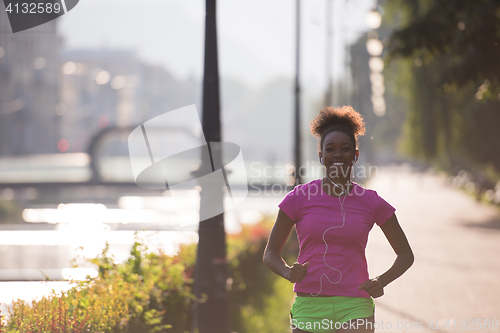 Image of african american woman jogging in the city