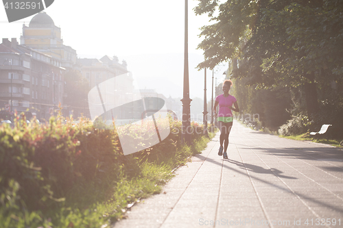 Image of african american woman jogging in the city