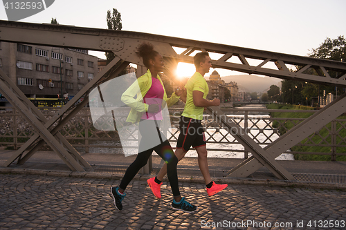 Image of young multiethnic couple jogging in the city
