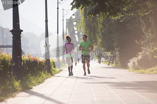 Image of young multiethnic couple jogging in the city