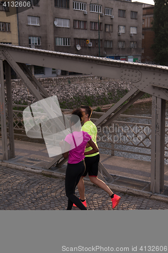 Image of young multiethnic couple jogging in the city