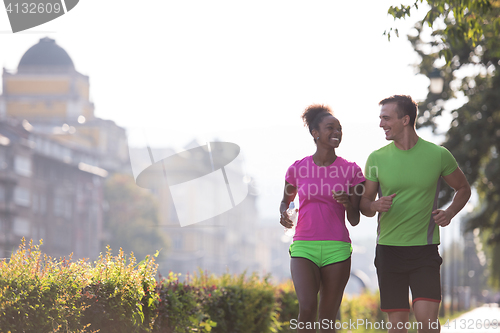 Image of young multiethnic couple jogging in the city