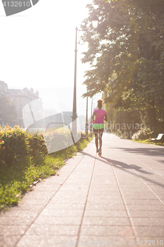 Image of african american woman jogging in the city