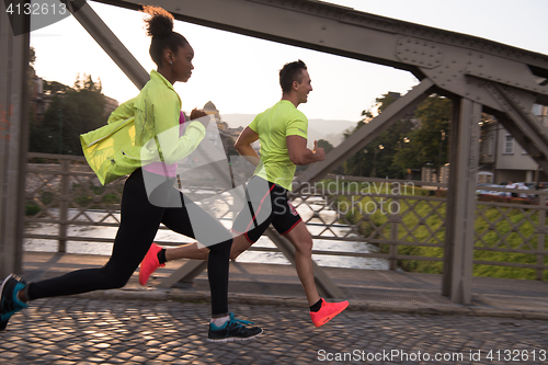 Image of young multiethnic couple jogging in the city