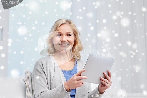 Image of happy middle aged woman with tablet pc at home