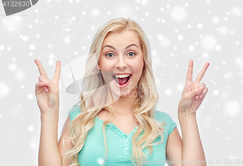 Image of smiling young woman or teenage girl showing peace