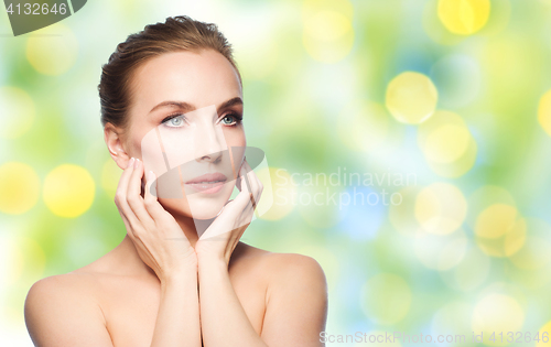 Image of beautiful young woman touching her face