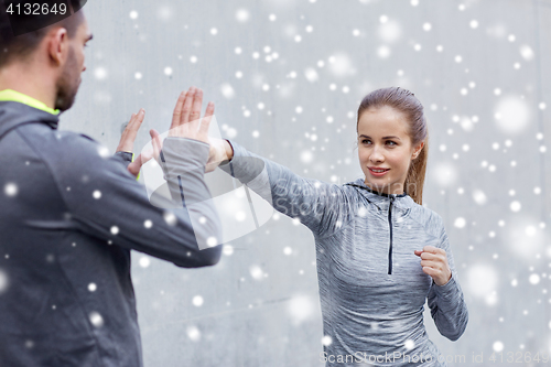 Image of happy woman with coach working out strike outdoors