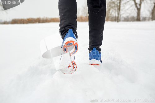 Image of close up of feet running along snowy winter road