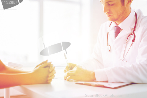 Image of patient and doctor taking notes