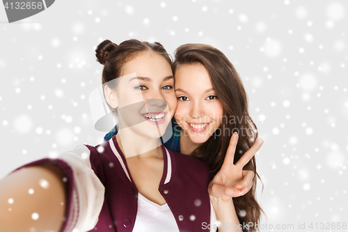 Image of happy friends taking selfie and showing peace