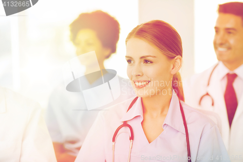 Image of happy doctor over group of medics at hospital