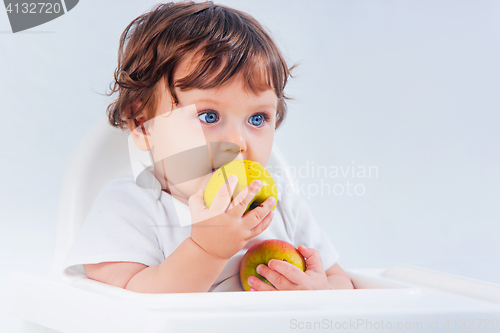 Image of Happy baby boy sitting and eating