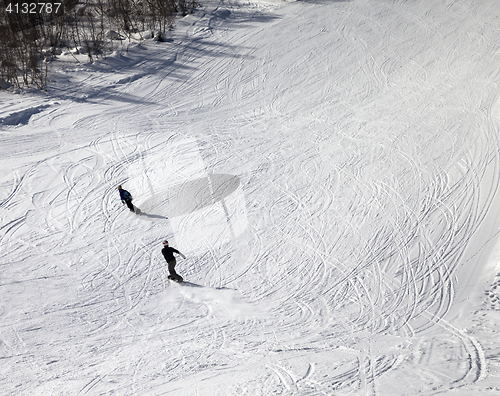 Image of Snowboarders on ski slope at sun winter day