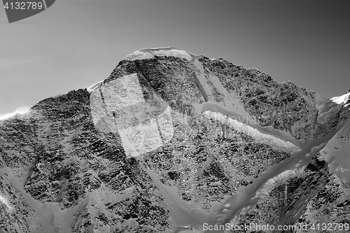 Image of Black and white view on mountains with snow in winter sun evenin