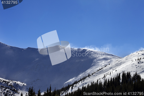 Image of Winter snow mountains at sunny windy day