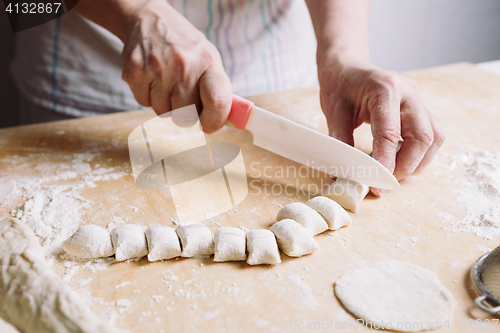 Image of Two hands making dough for meat dumplings.