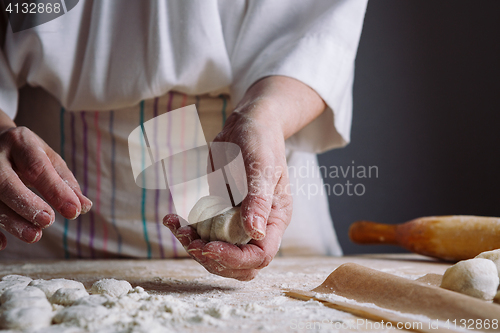 Image of Two hands making dough for meat dumplings.