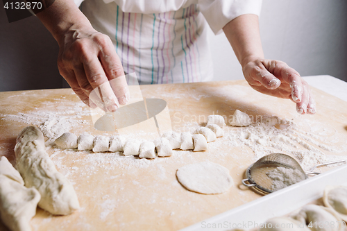 Image of Two hands making dough for meat dumplings.