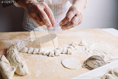 Image of Two hands making dough for meat dumplings.