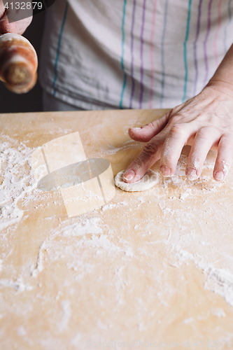 Image of Two hands making dough for meat dumplings.