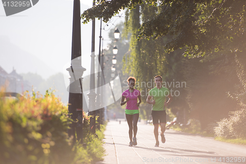 Image of young multiethnic couple jogging in the city