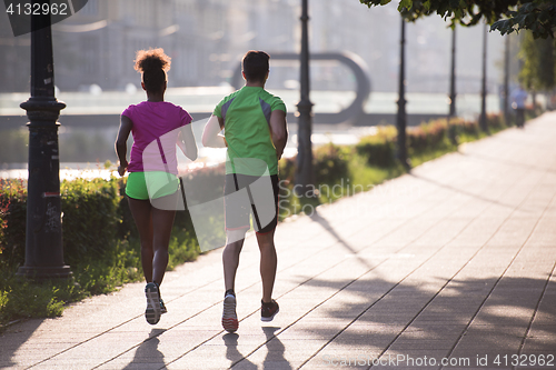 Image of young multiethnic couple jogging in the city