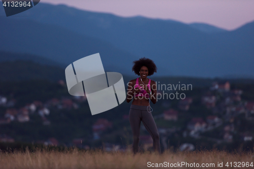 Image of Young African american woman jogging in nature