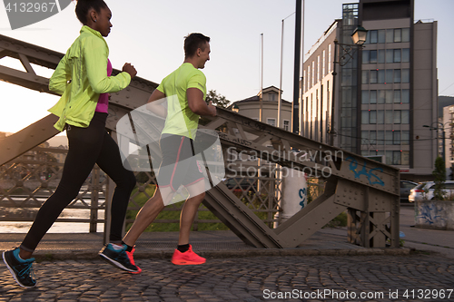 Image of young multiethnic couple jogging in the city
