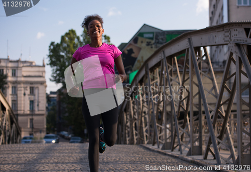 Image of african american woman running across the bridge