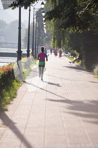 Image of african american woman jogging in the city