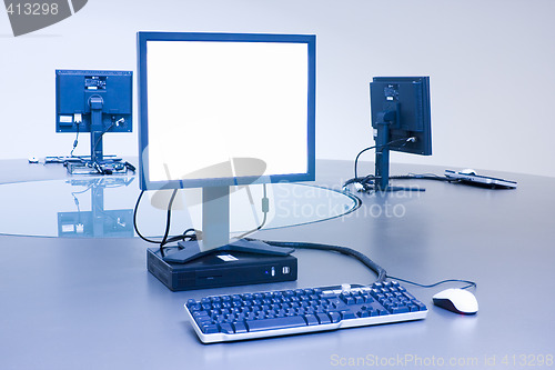 Image of Three computers on desktop